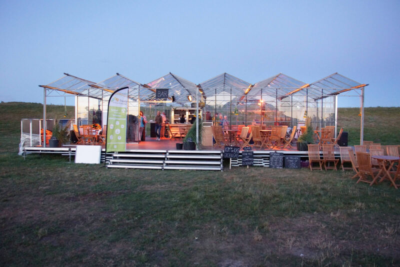 De kassen van kasverhuur creëren intimiteit in een grote, open (buiten)ruimte-min