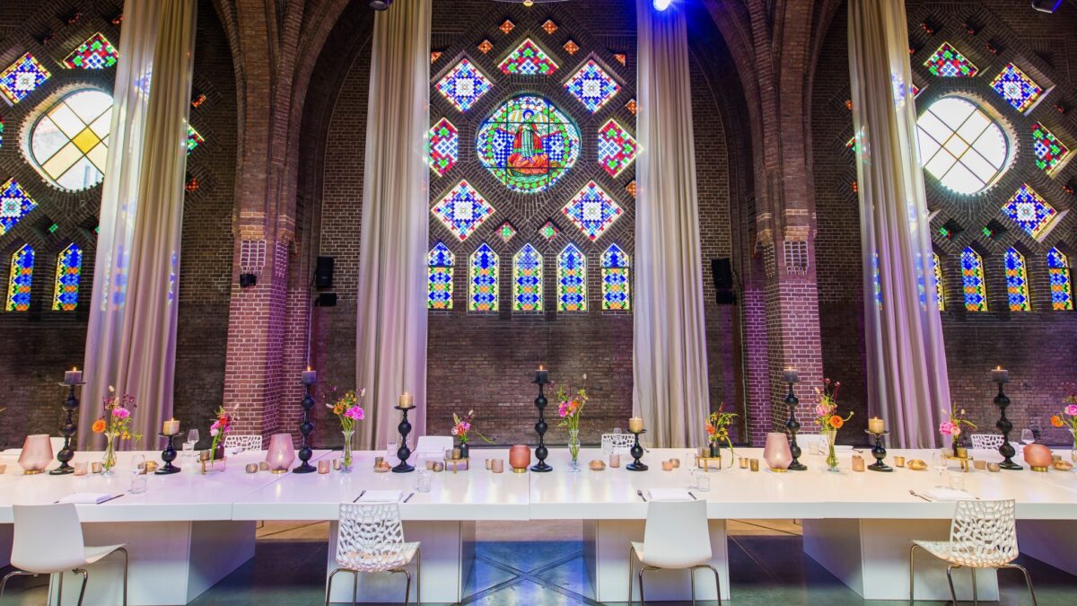 Diner-aan-lange-tafel-onder-glas-in-lood-bij-DOMUSDELA (beeld: Twycer)