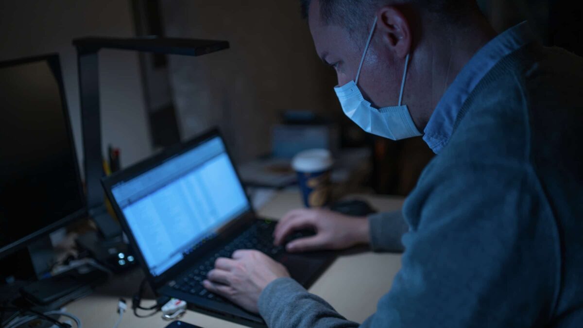 Coronavirus - man met mondkapje -laptop