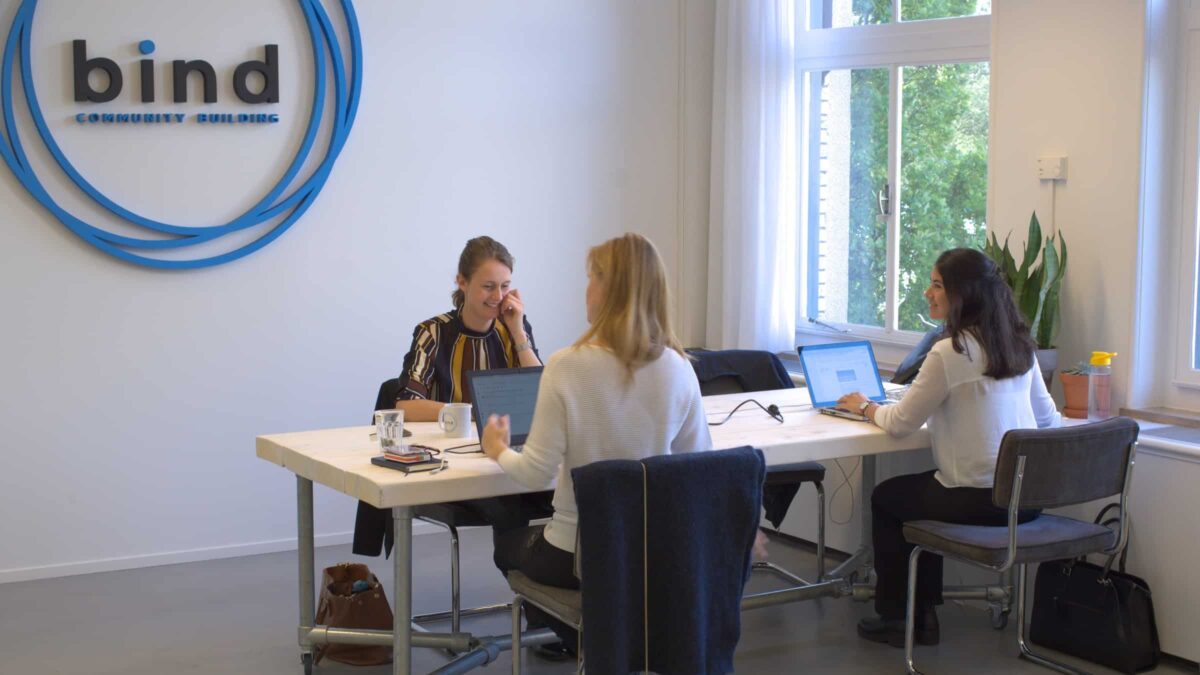 3 mensen aan het werk op het kantoor van Bind community building