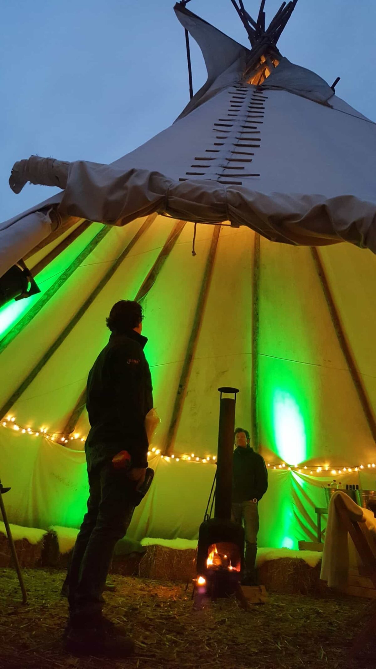 Event Inspiration - Buiten in de kuil verlichte tipitent met mensen bij een heater