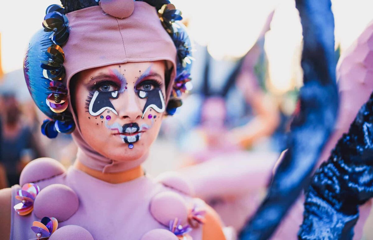 Gesminkte artieste met roze kleding en hoed met futuristisch uiterlijk (© TK Photography)