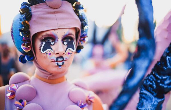 Gesminkte artieste met roze kleding en hoed met futuristisch uiterlijk (© TK Photography)