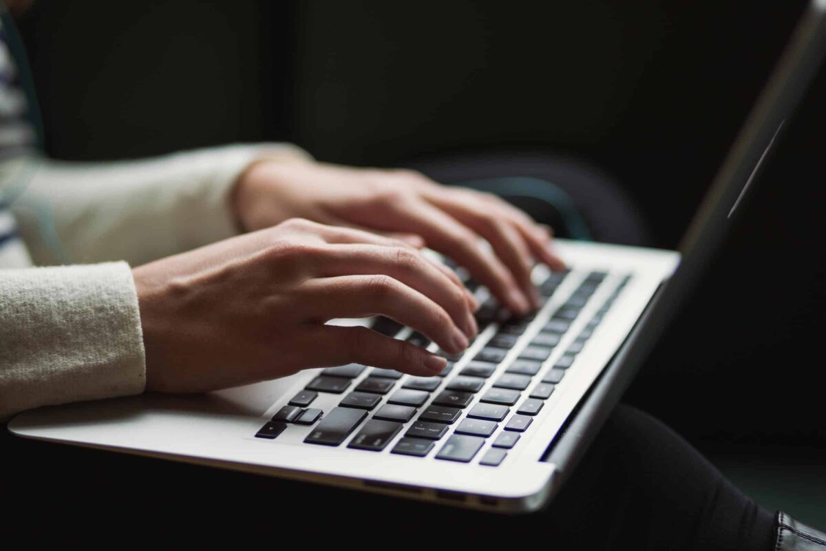 Handen die aan het tikken zijn op een laptop