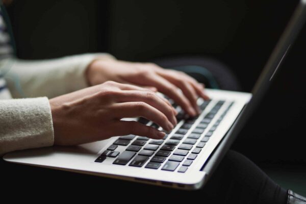 Handen die aan het tikken zijn op een laptop