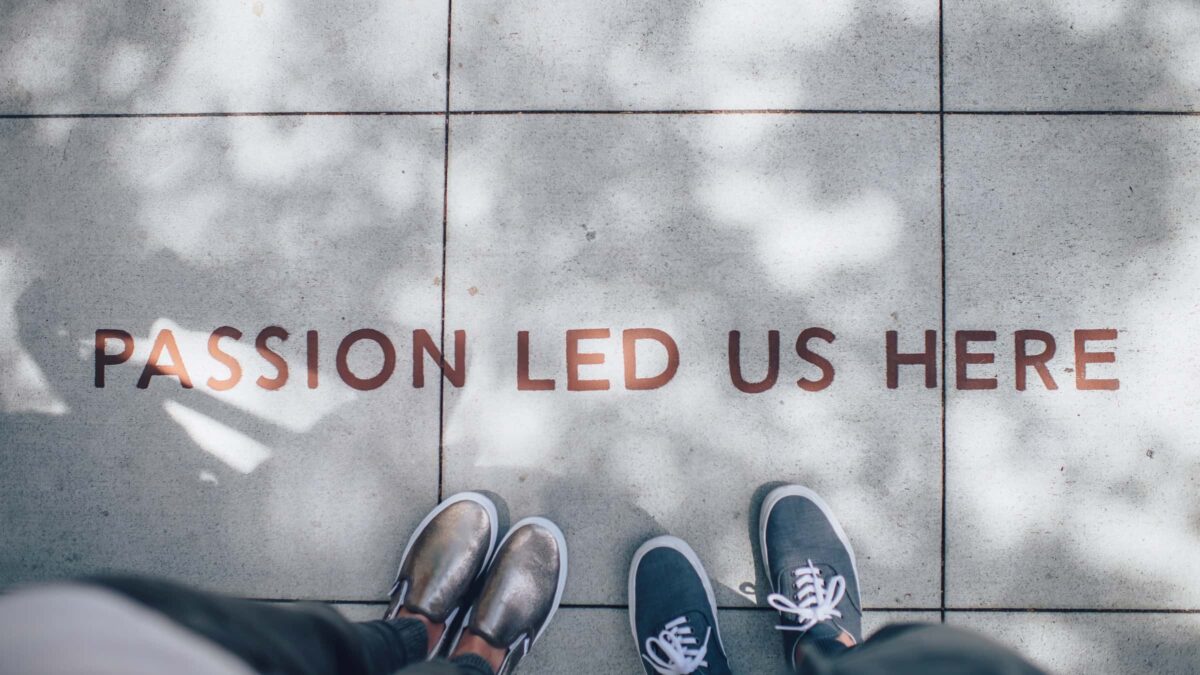 passion led us here met verf op de grond geschreven naast twee paar benen