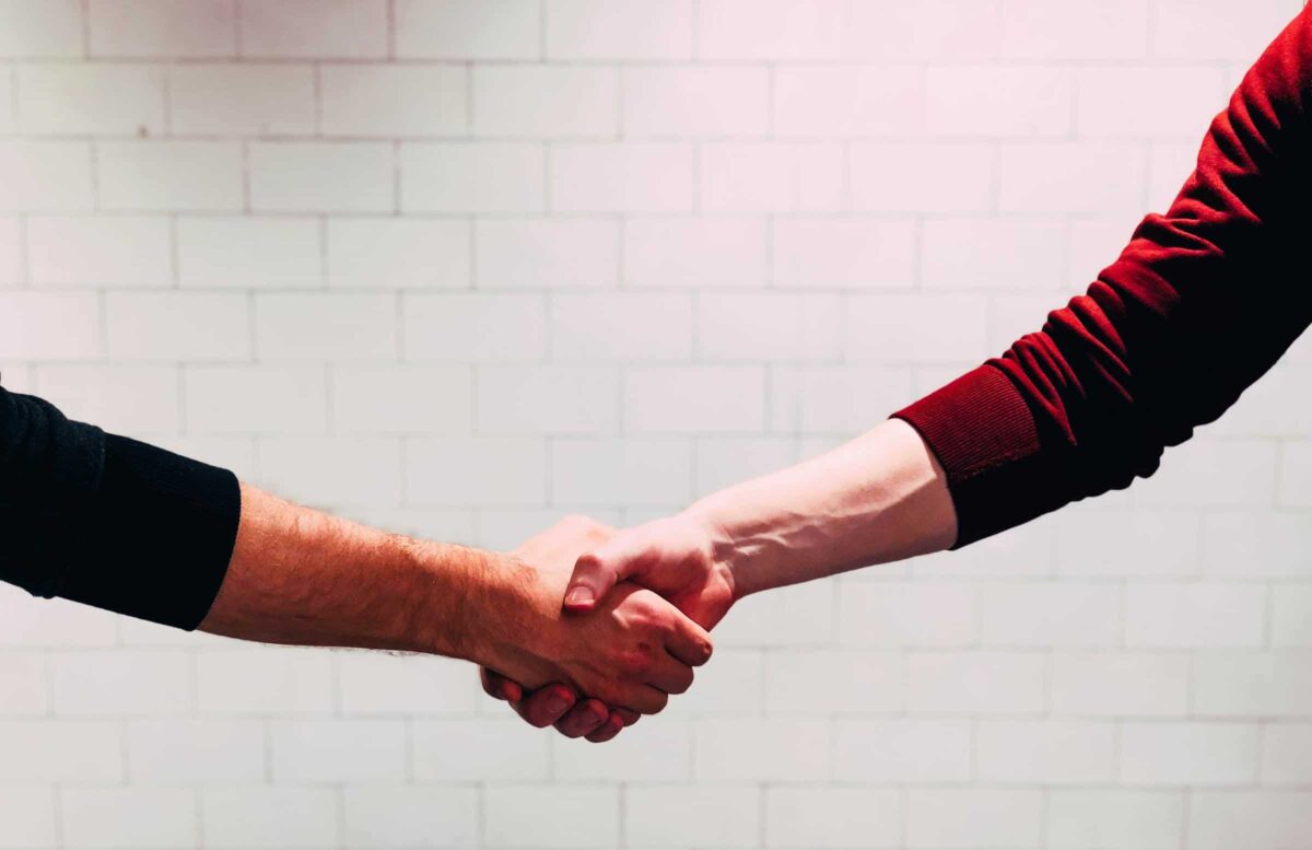 twee mensen die elkaar de hand geven