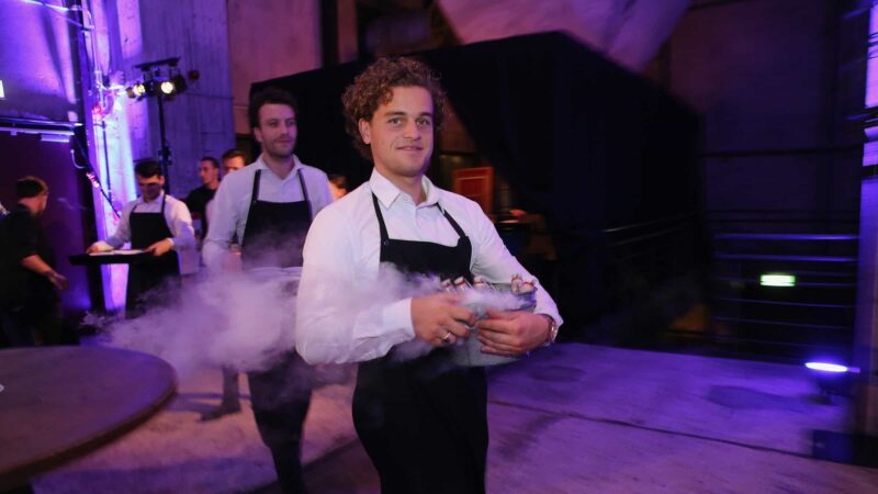 Bediening met bakken met ijs en drankjes waar rook uit komt