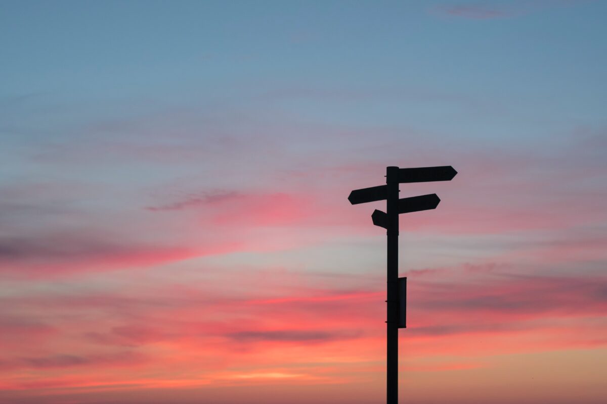 Wegwijzer in de schemering met een gekleurde lucht (Photo javier-allegue-barros)