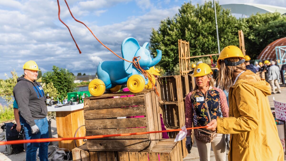 Chainreaction twee vrouwen en een man die een kettingreactie maken met een blauw olifantje