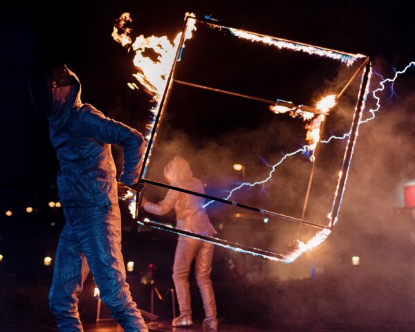 Kubus die in brand staat en een man houdt deze vast tijdens Tesla event