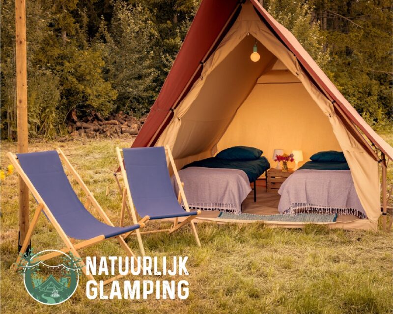 Natuurlijk Glamping tent met twee stoelen ervoor en twee bedden in de tent