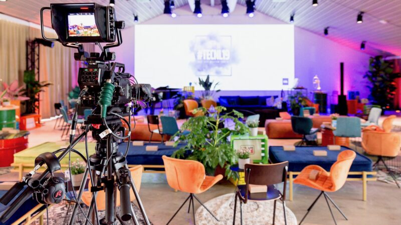 TechNL 19 hybride event met zitjes, podium en camera We Are Live