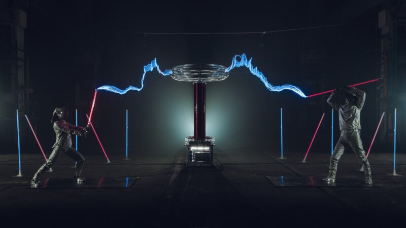 Twee zwaardvechters met lichtgevende zwaarden en electriciteit tijdens Tesla event