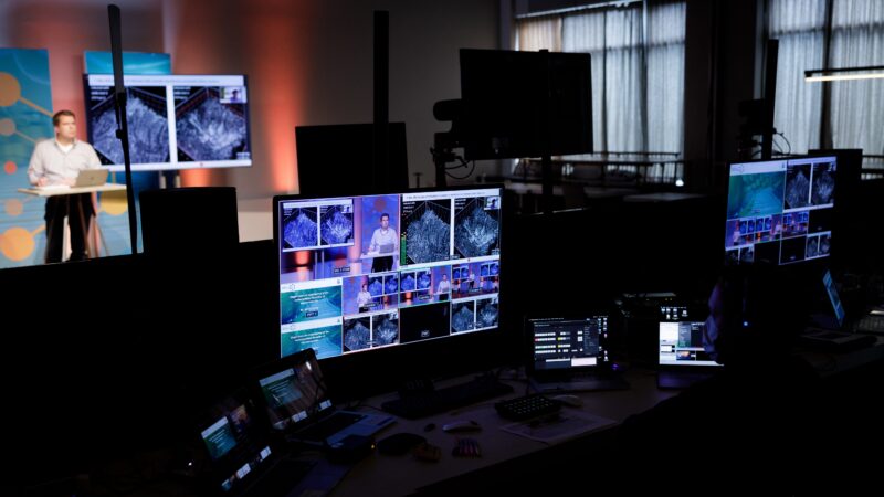 Amplify EventMarketing online event presentator bij scherm en meerdere camerahoeken op pc (Photo: Bram Saeys)