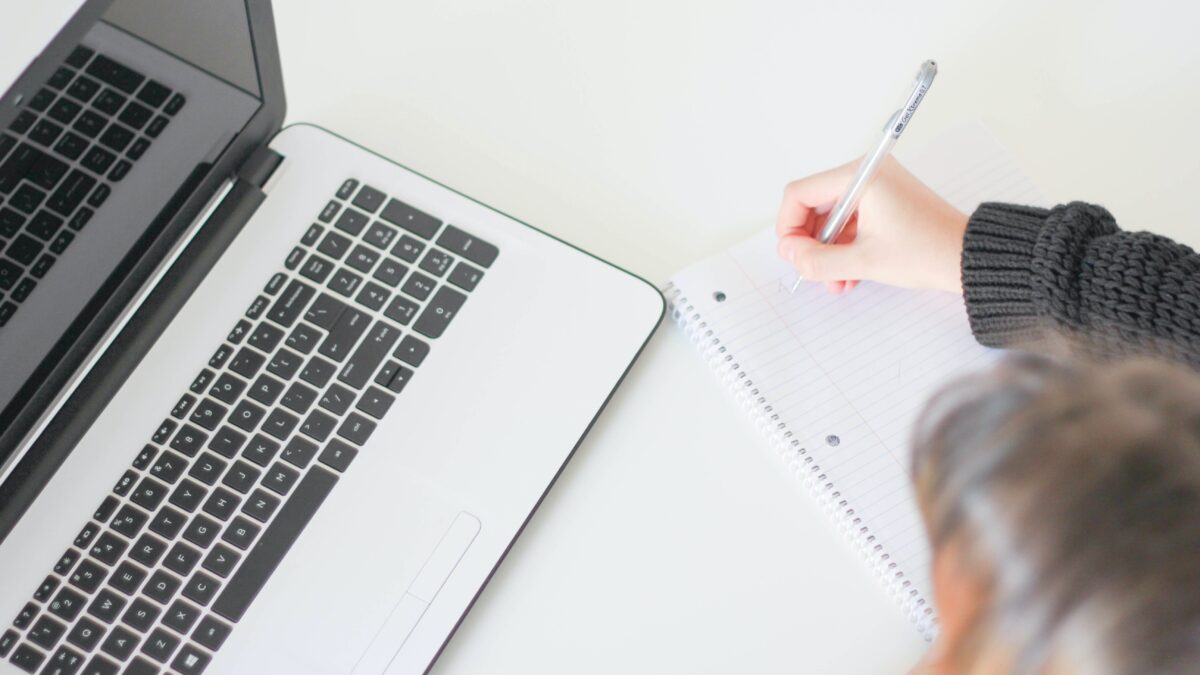 Online live events op apple pc met vrouw met notitieblok ernaast