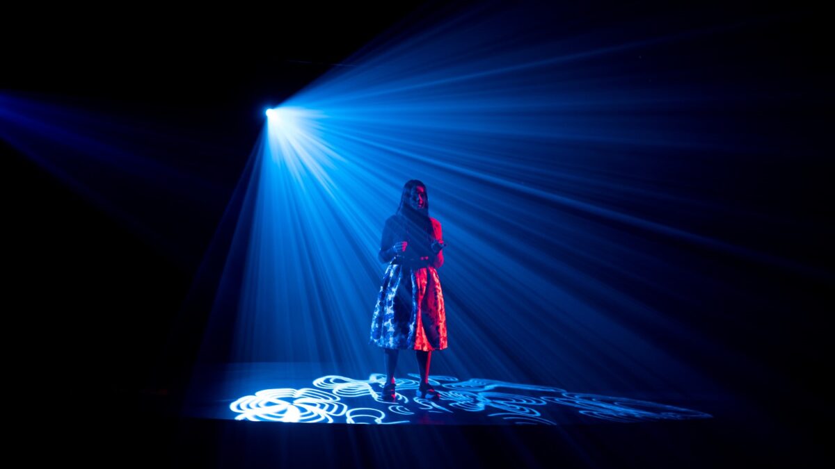 Vrouw op podium verlicht - Dennis Khalil