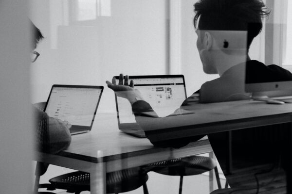 Twee mannen op laptop aan tafel