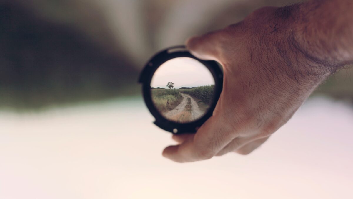 Lens met vergezicht in de hand van een man