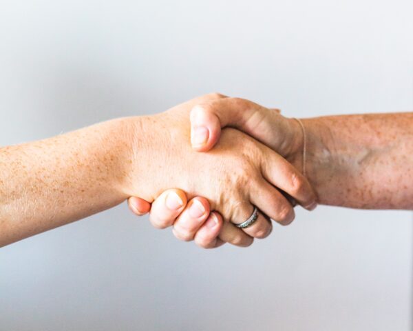 Twee handen die elkaars hand schudden