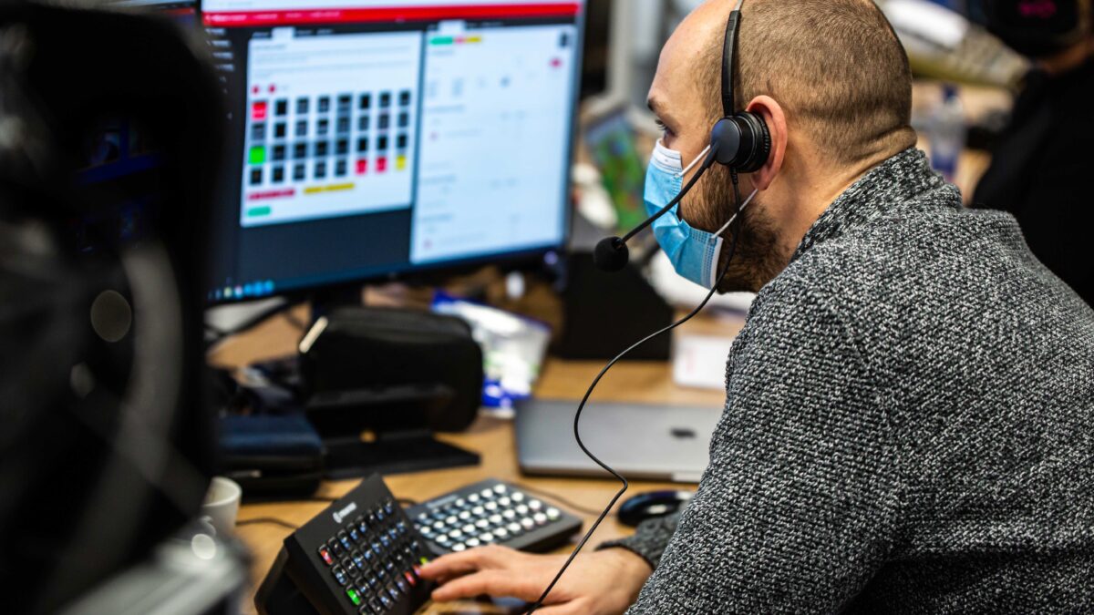 Unlimited Productions medewerker achter paneel met knoppen tijdens online event