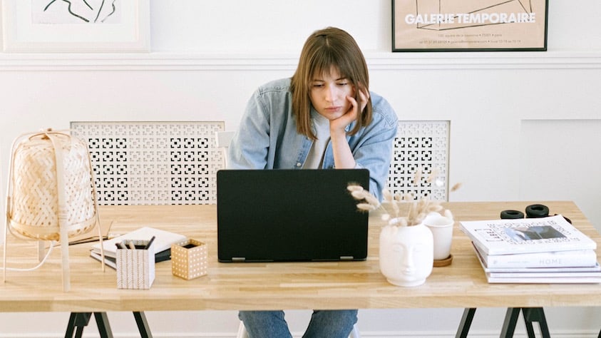 Vrouw die zich verveelt achter een laptop