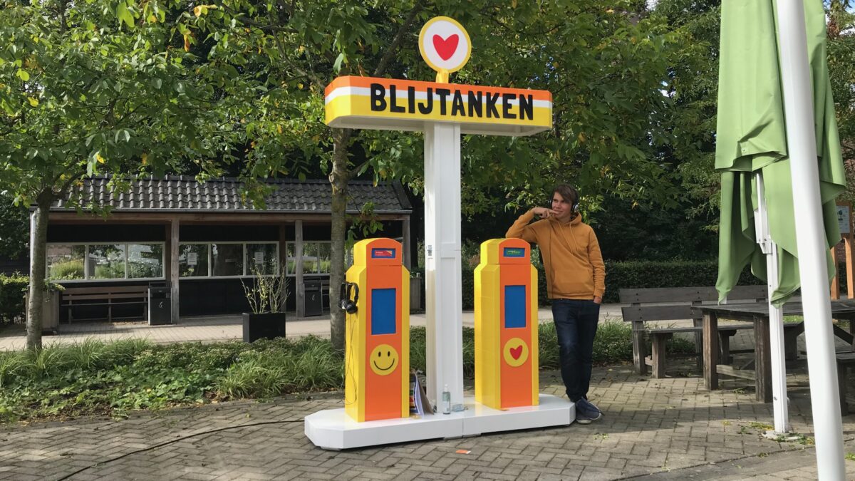 Blijtanken benzinepomp met koptelefoons
