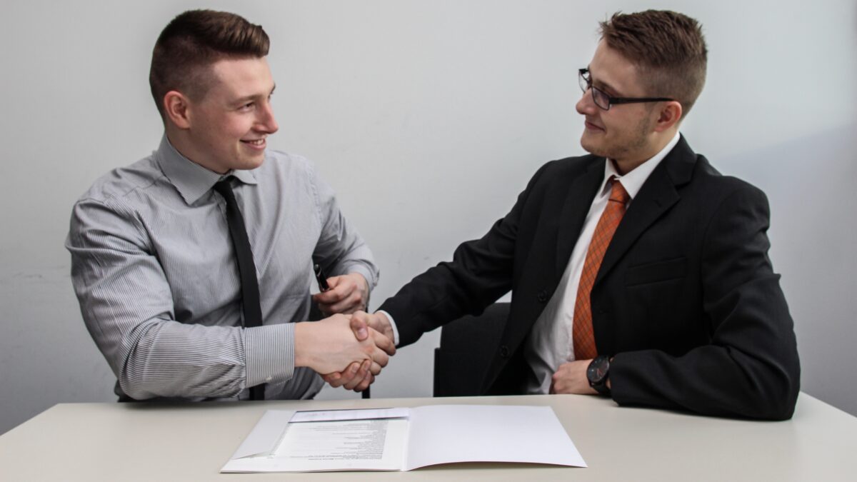 Twee mensen die elkaar een hand geven - contract